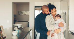 man embracing woman and baby