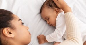 woman lying with sleeping baby