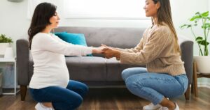 doula swatting with pregnant woman holding hands