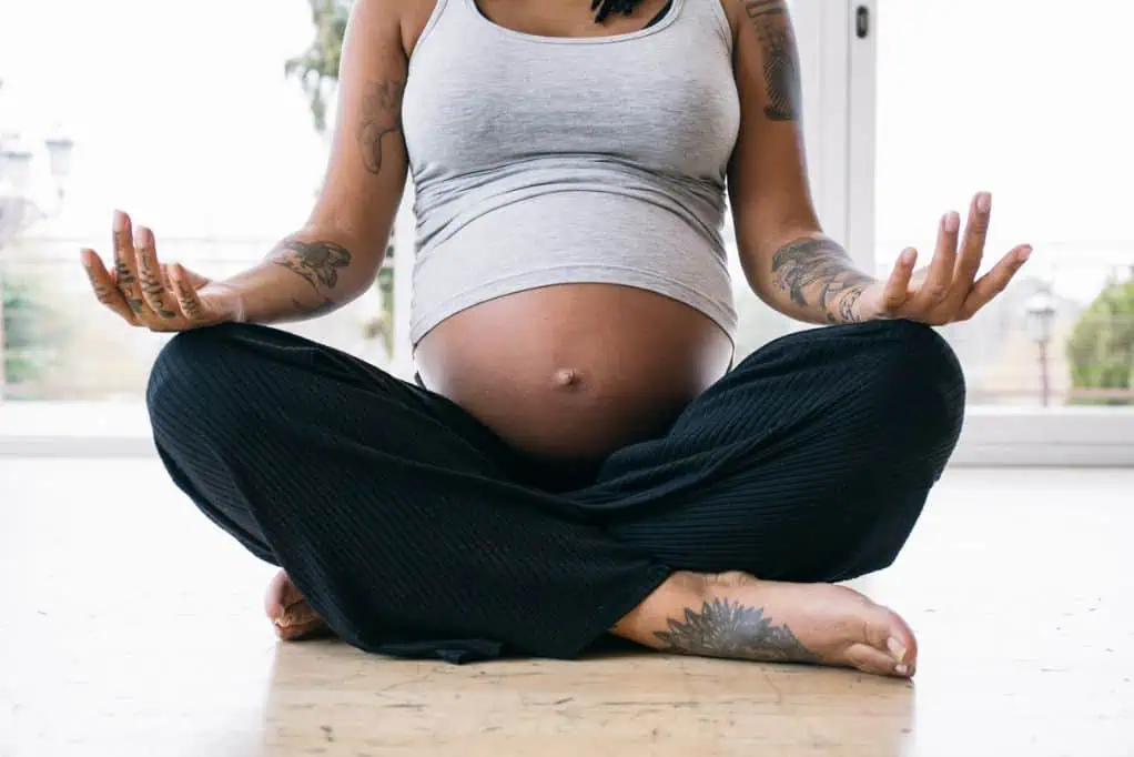 Pregnant woman meditating in a bright room